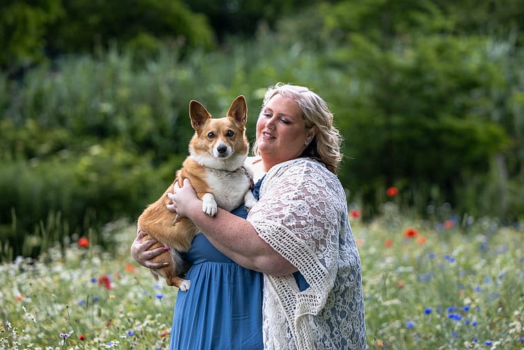 a dog mom holding her corgi at a wildflower field in Dundas, ON